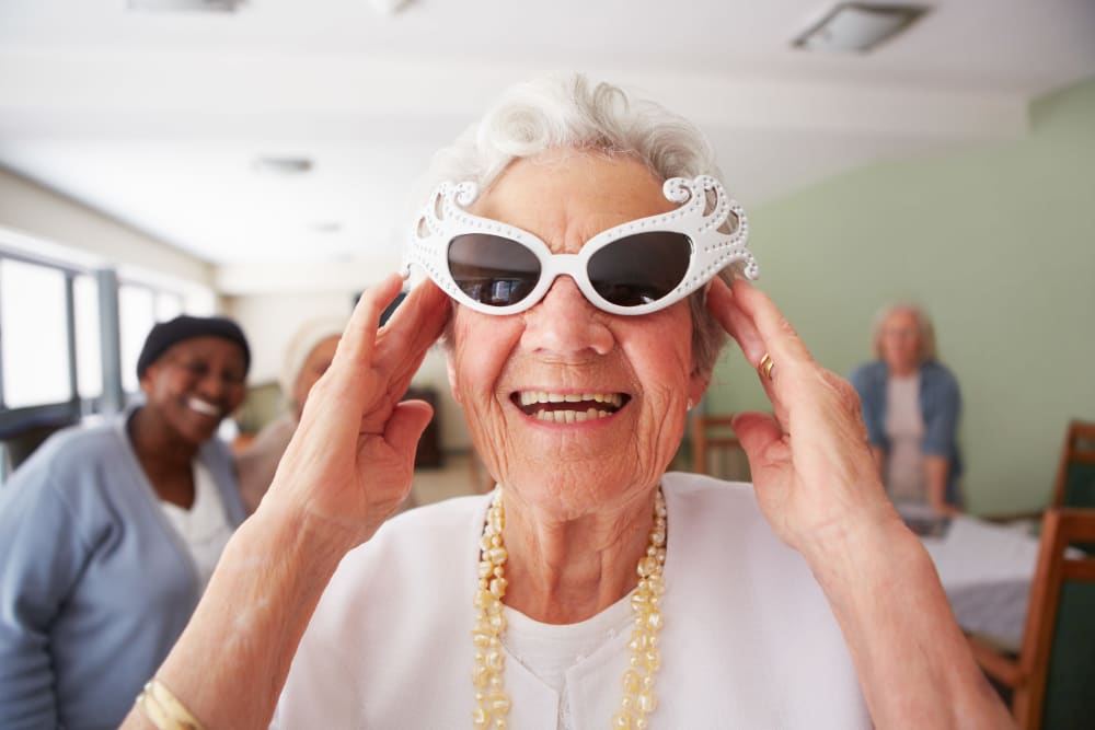 Resident smiles for the camera with stylish sunglasses at Arlington Place of Grundy Center in Grundy Center, Iowa