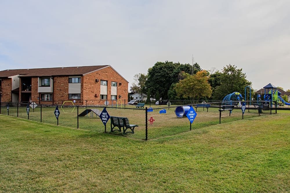 Fenced dog park with agility equipment at Webster Manor Apartments in Webster, New York