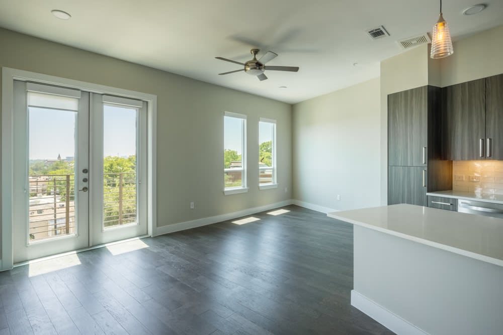 Gorgeous hardwood floors and a ceiling fan in the open-concept living space of a model home at Magnolia Heights in San Antonio, Texas