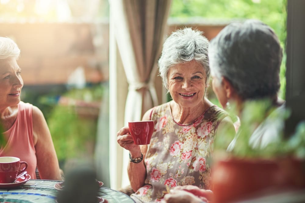 Senior ladies drinking tea and laughing at HOLI Senior Living in Hillsboro, OR