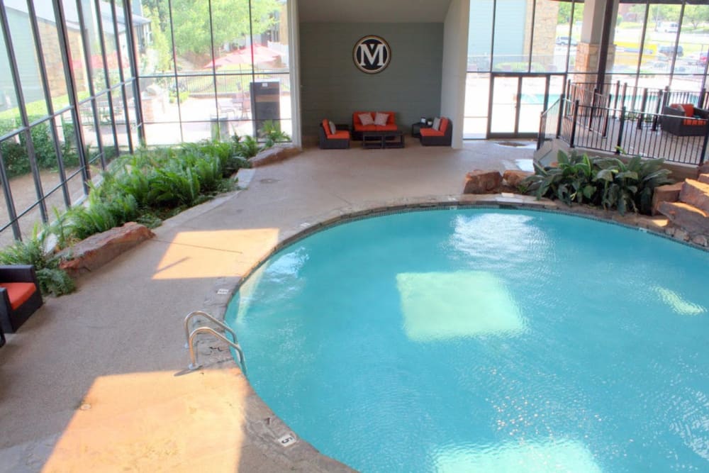 An indoor swimming pool with a deck at Goldelm at Metropolitan in Knoxville, Tennessee