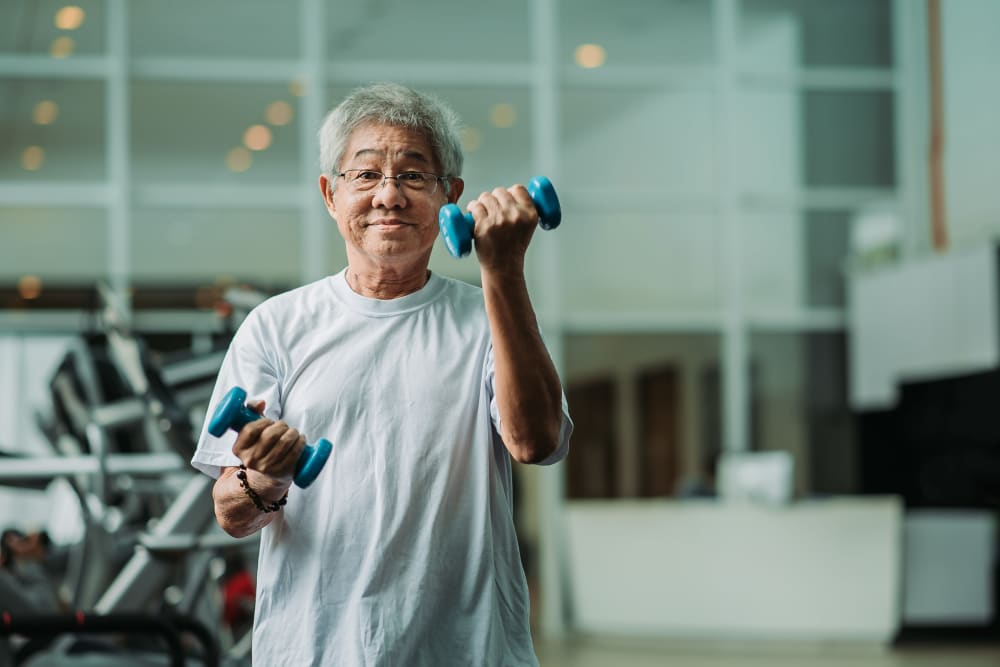Resident lifting light weights at Ray Stone Senior Living in Sacramento, California