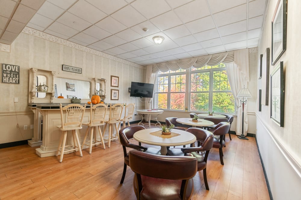 Care dining area with 3-person tables and a bar at The Hearth at Gardenside in Branford, Connecticut