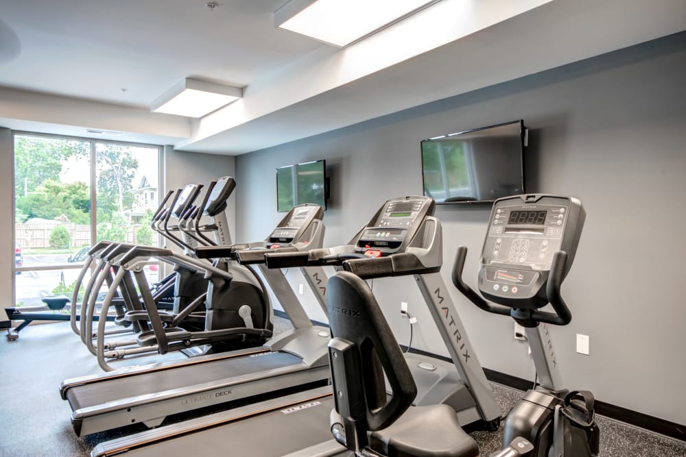 A fitness center with plenty of TVs at Manassas Station Apartments in Manassas, Virginia