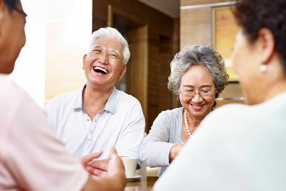 Friends chatting outside of their apartments at Campus Commons Senior Living in Sacramento, California