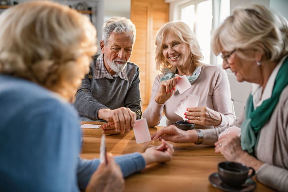 Friends playing cards at Campus Commons Senior Living in Sacramento, California