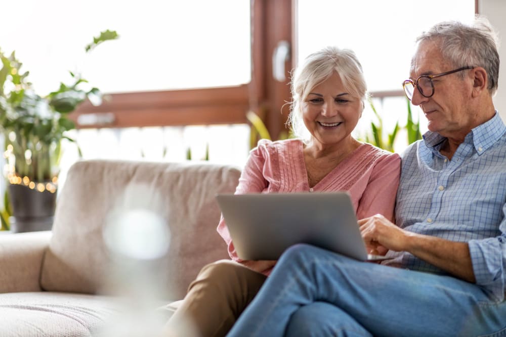 Couple looking at their laptop together at Campus Commons Senior Living in Sacramento, California