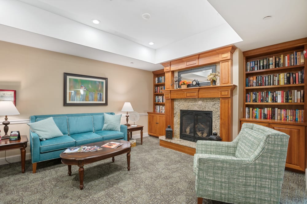 Lounge with a fireplace, full bookshelves and places to sit at The Hearth at Hendersonville in Hendersonville, Tennessee