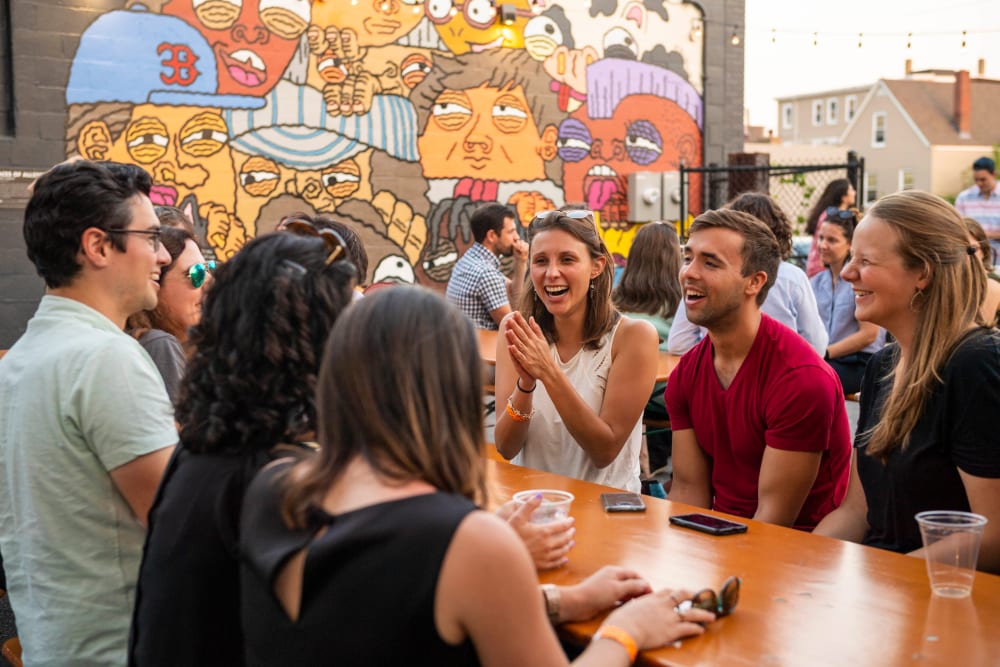 Friends enjoying Drinks and stories in Allston, Massachusetts near Arthaus Apartments