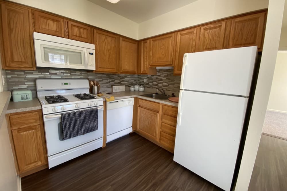 Kitchen with white appliances and vinyl plank flooring at Sherry Lake Apartment Homes in Conshohocken, Pennsylvania