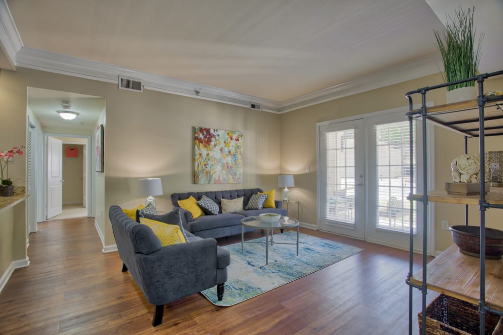 Living room with double doors to outdoor patio at Atkins Circle Apartments & Townhomes in Charlotte, North Carolina