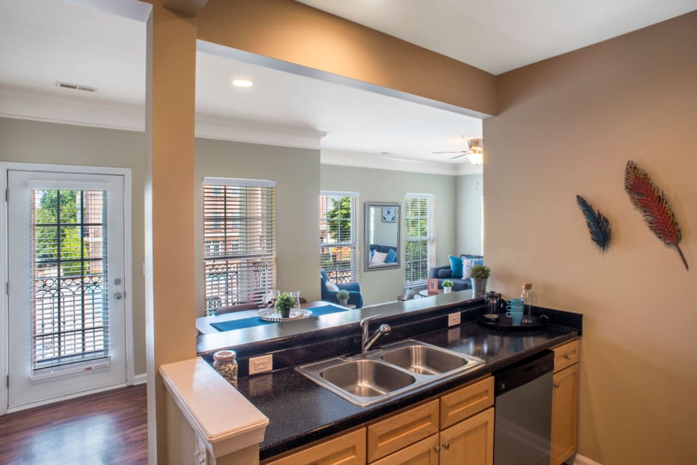 Kitchen sing with breakfast bar behind at Worthington Apartments & Townhomes in Charlotte, North Carolina