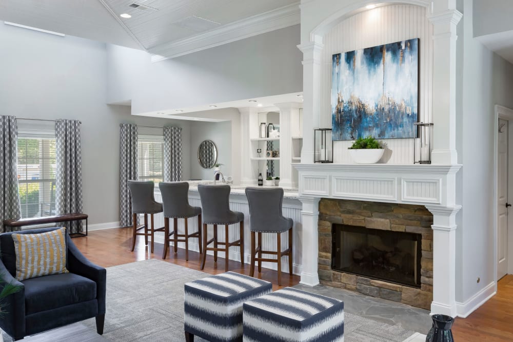 Resident clubhouse lounge with a fireplace and bar seating at The Vinings at Newnan Lakes in Newnan, Georgia