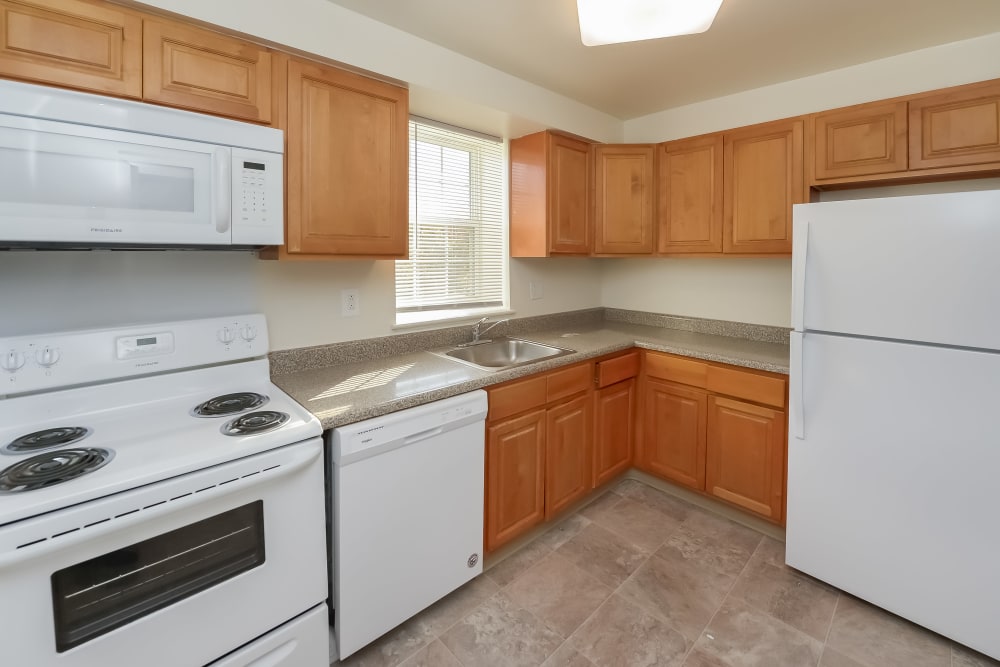 Kitchen with maple cabinets and white appliances at Woodacres Apartment Homes in Claymont, DE