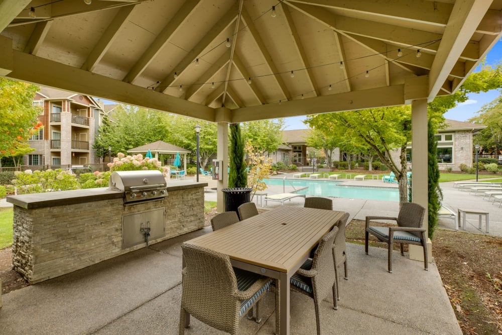 A grilling area by the pool at dusk at The Grove at Orenco Station in Hillsboro, Oregon