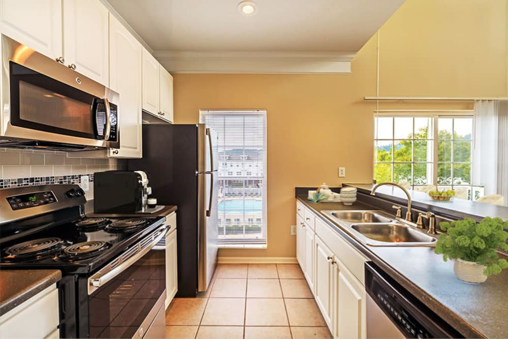 Tiled kitchen with white cabinets at The Waterfront Apartments & Townhomes in Munhall, Pennsylvania