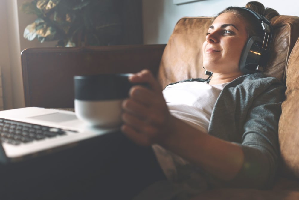 Woman enjoying coffee while on her computer at Hollybrook Farms Apartments in Laurel, Delaware