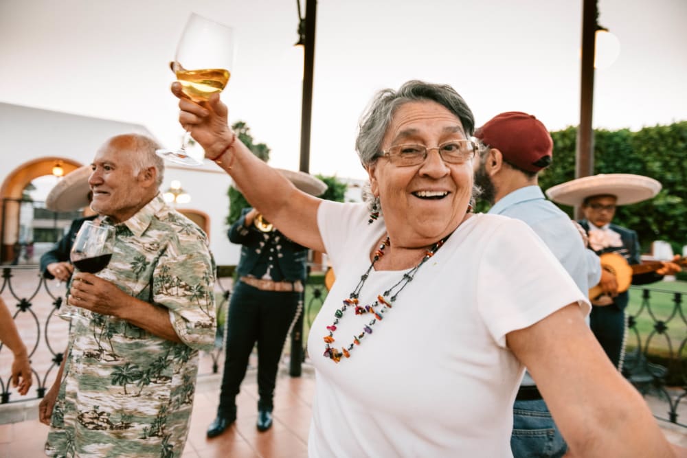 Woman drinking wine and dancing at Fairbrooke Senior Apartments in Aberdeen, Maryland