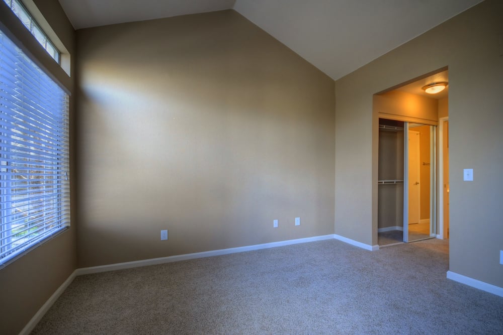 A bedroom with a large window at Larkspur Woods in Sacramento, California