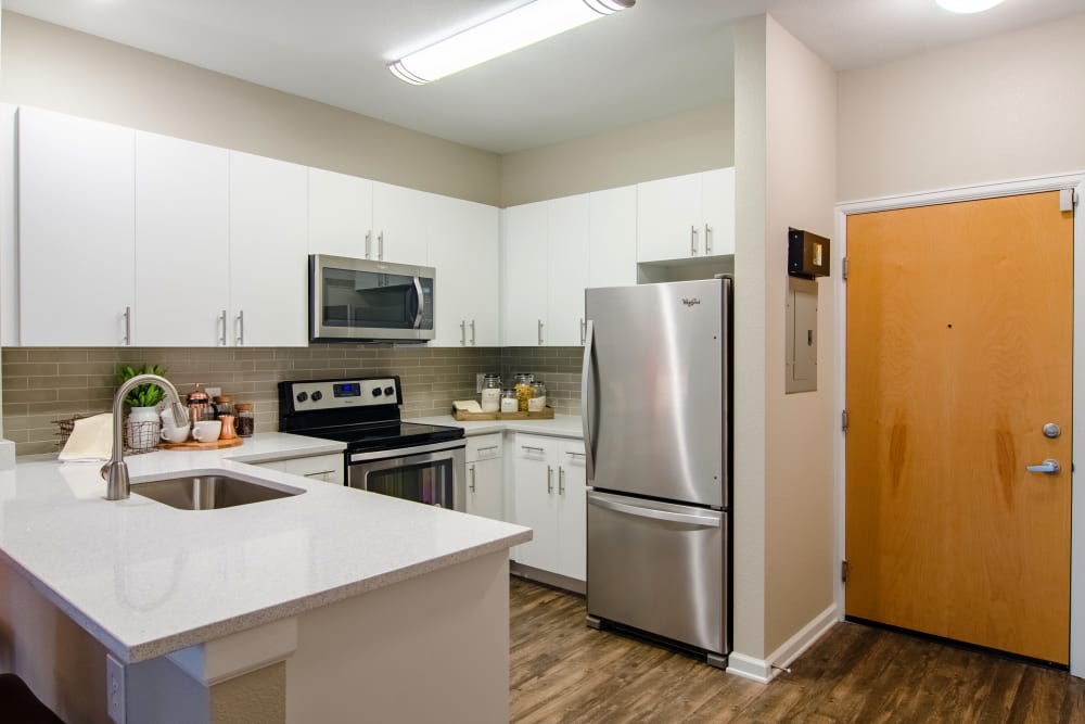 Sleek kitchen with quartz counters at Summit at Flatirons Apartments in Broomfield, Colorado