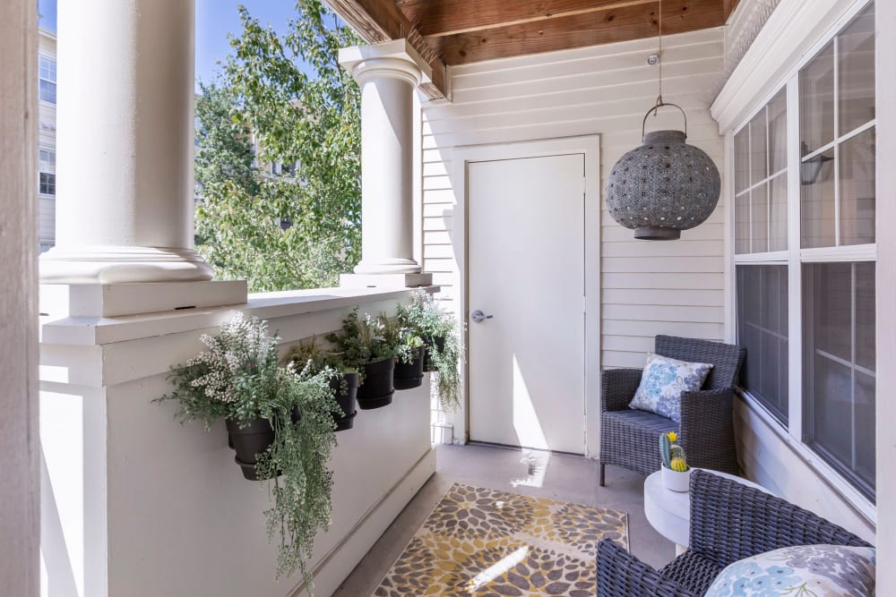 Private balcony with cozy seating area in model home at Sofi at Salem Station in Salem, Massachusetts
