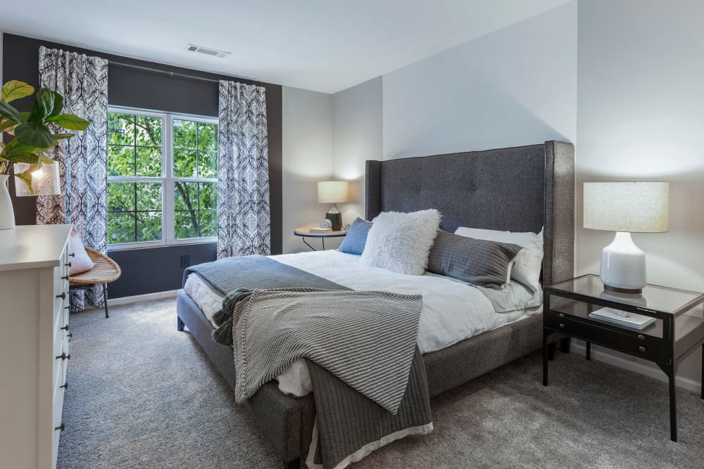 Furnished bedroom with large windows at Sofi at Salem Station in Salem, Massachusetts