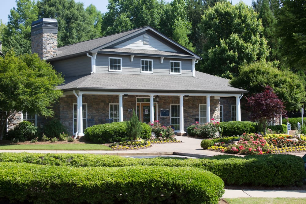 Exterior view of the leasing office surrounded by professionally maintained landscaping at The Vinings at Newnan Lakes in Newnan, Georgia
