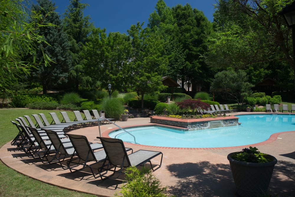 Chaise lounge chairs and mature trees around the pool area at The Vinings at Newnan Lakes in Newnan, Georgia
