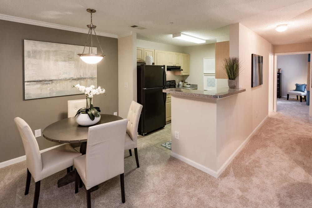 Dining nook with an accent wall next to a model home's kitchen at The Vinings at Newnan Lakes in Newnan, Georgia