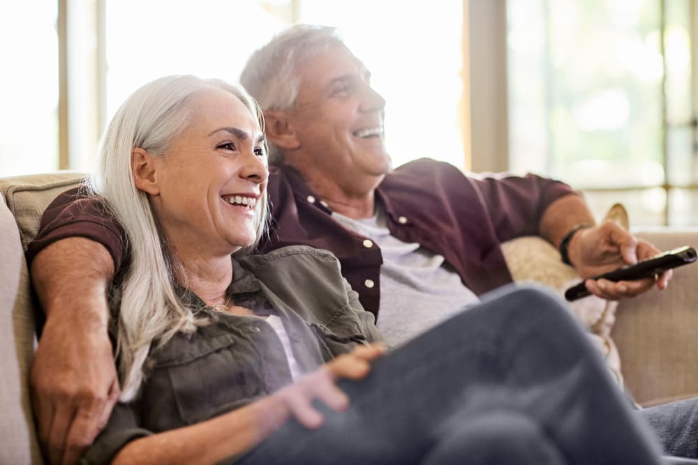 Resident sitting on their couch and watching TV together at Lakeview Residences in Aurora, Illinois