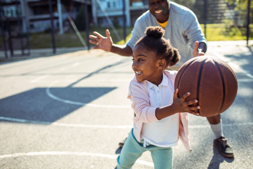 Resident and their kid playing basketball together at Autumn Ridge in Waukee, Iowa