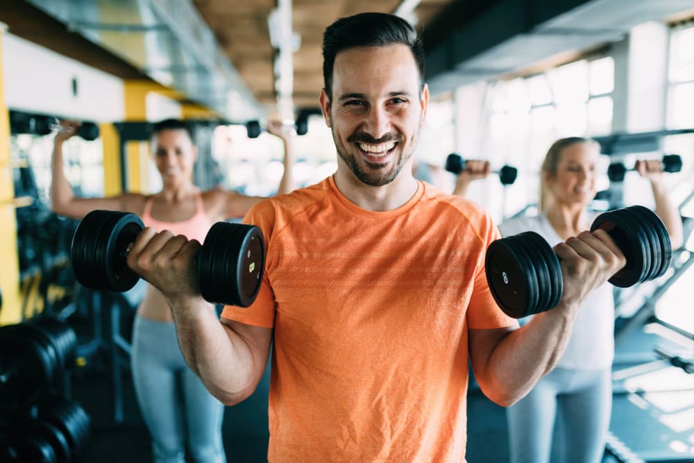 Man at fitness center working out with a smile on his face at Trails of Towne Lake in Irving, Texas