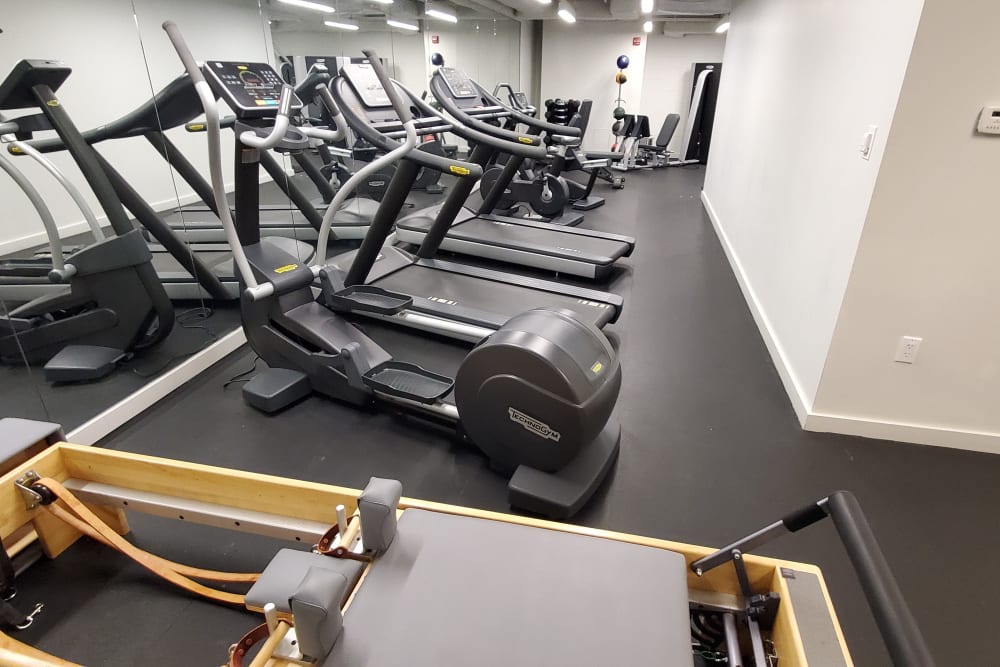 A fitness center with individual workout stations at Square 50 Apartments in Washington, District of Columbia
