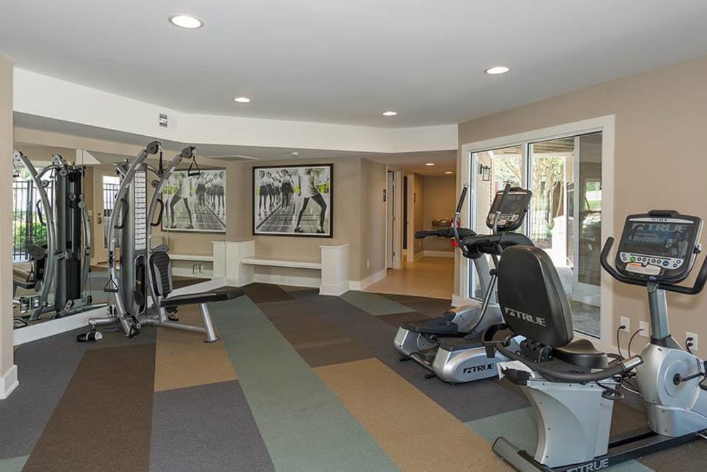 A fitness center with individual workout stations at Residences at Belmont in Fredericksburg, Virginia
