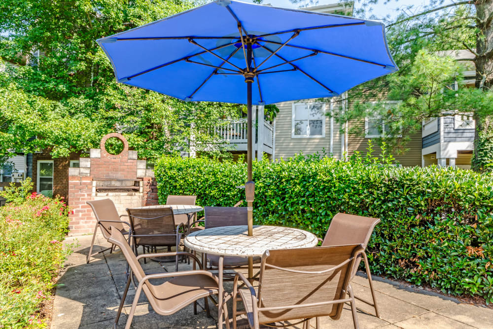 Tables and chairs with umbrellas for shade at Residences at Belmont in Fredericksburg, Virginia