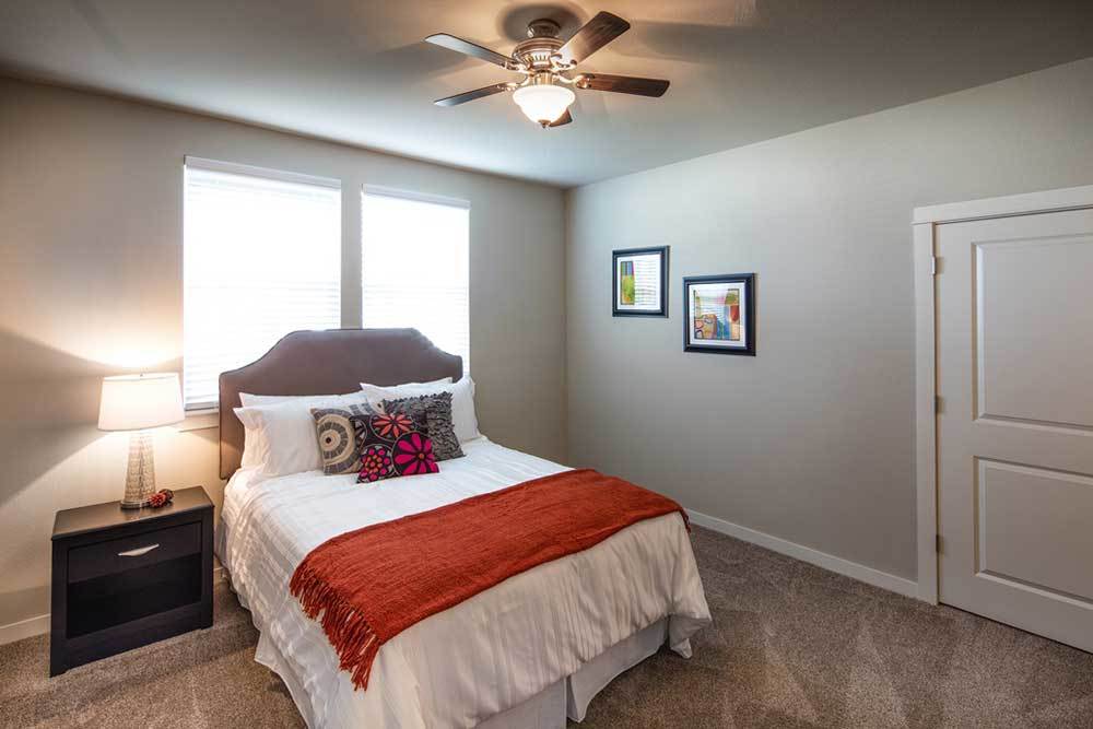 A bedroom with a large window at Traditions at Mid Rivers in Cottleville, Missouri