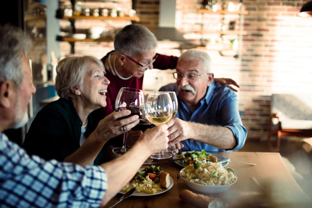 Friends sharing dinner and drinks at Roseville Commons Senior Living in Roseville, California