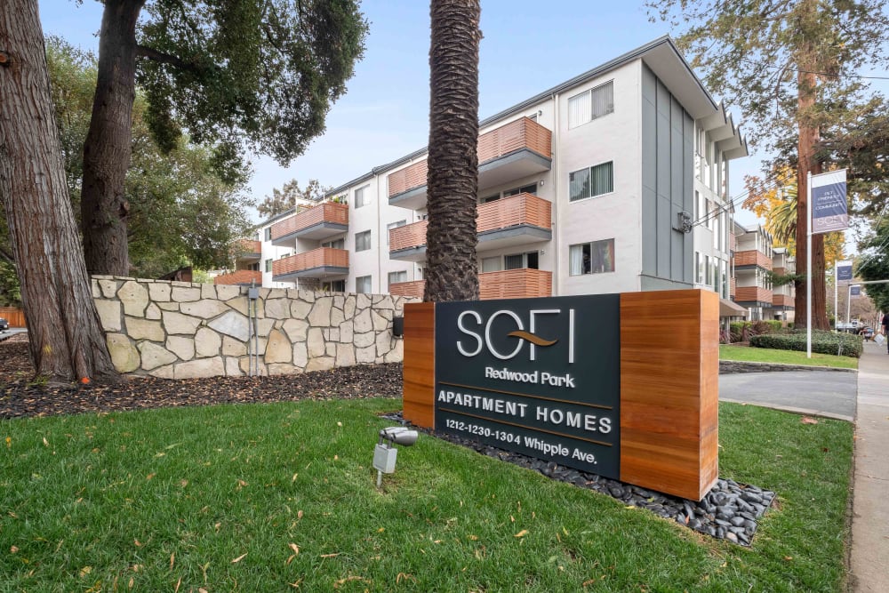 Well-maintained lawns and landscaping along the sidewalk outside resident buildings at Sofi Redwood Park in Redwood City, California