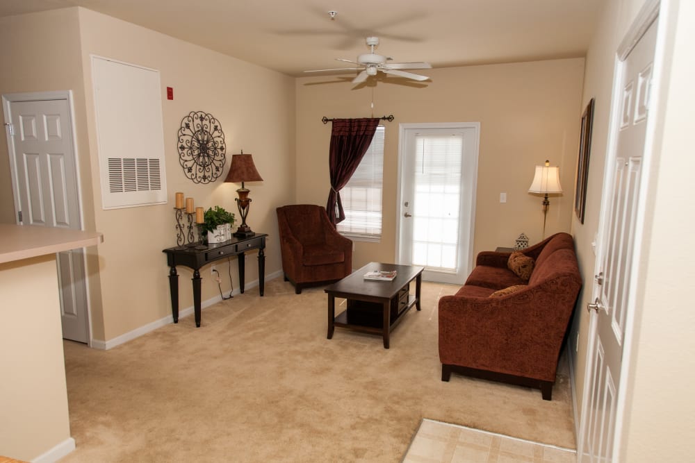 A living room with plush carpeting at O'Fallon Lakes in O'Fallon, Missouri