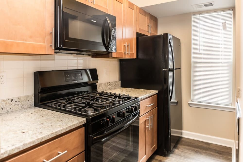 A kitchen with wood-style cabinets at Greenhills Apartments & Townhomes in Damascus, Maryland