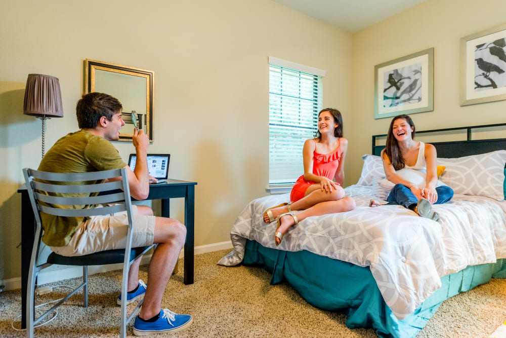 Friends hanging out in one of the spacious bedrooms at Ikon Athens in Athens, Georgia
