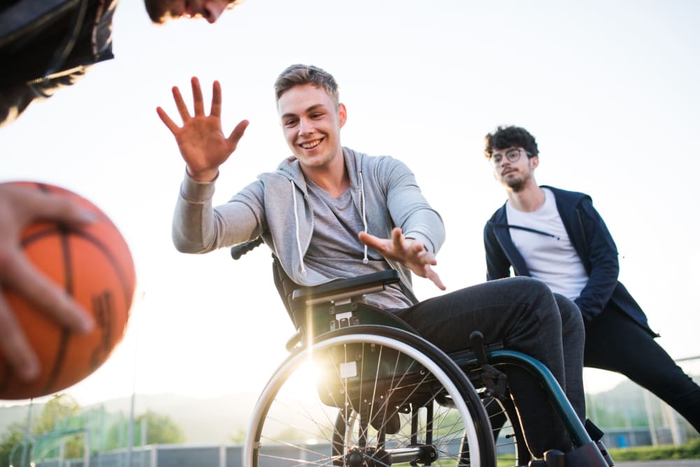Student in wheelchair playing basketball with friends at Ikon Athens in Athens, Georgia