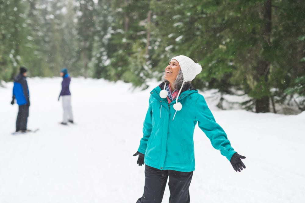 A woman enjoying the snowfall at Applewood Pointe of Westminster in Westminster, Colorado
