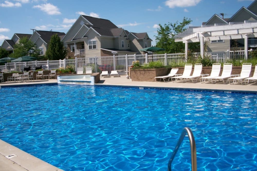 Sparkling swimming pool surrounded by lounge chairs at Avalon at Northbrook Apartments & Townhomes in Fort Wayne, Indiana