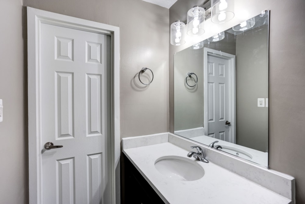 Bathroom with lots of lighting and large mirror at The Cambridge Apartments in Washington, District of Columbia