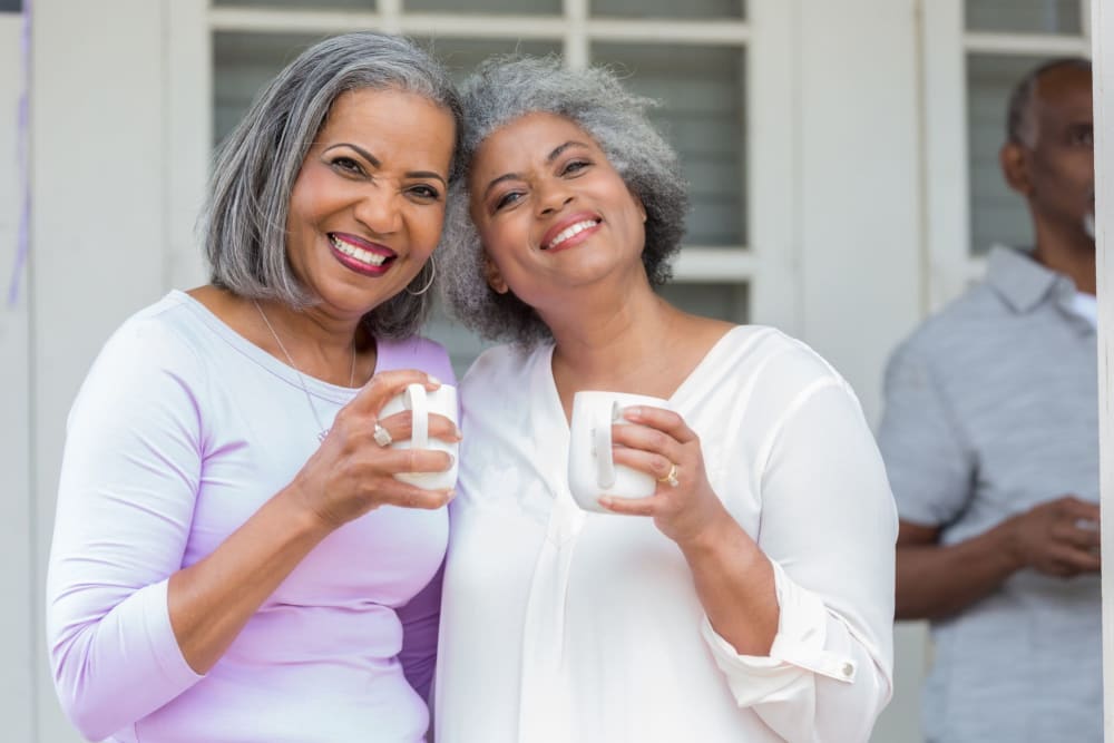 Two friends having a cup of coffee posing for a photo at Leisure Manor Apartments in Sacramento, California