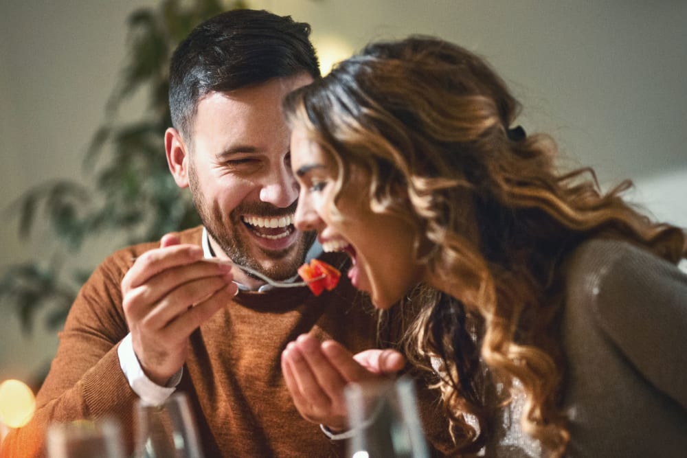 Couple feeing each other a bite of dinner enjoying the night at Summerfield at Morgan Metro in Landover, Maryland