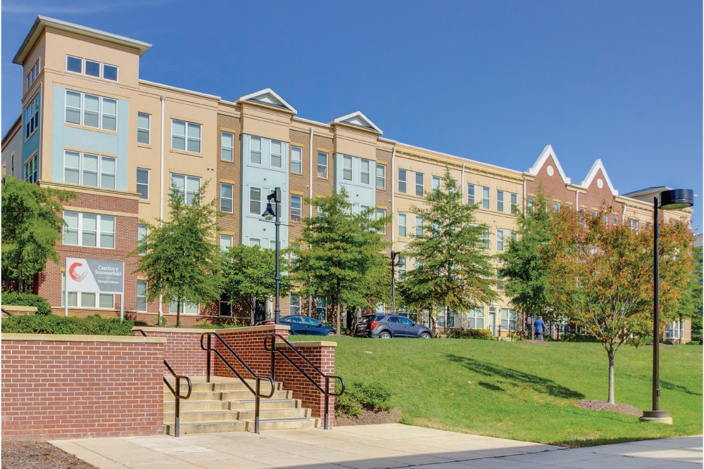 Exterior building with parking lot and green grass area at Summerfield at Morgan Metro in Landover, Maryland
