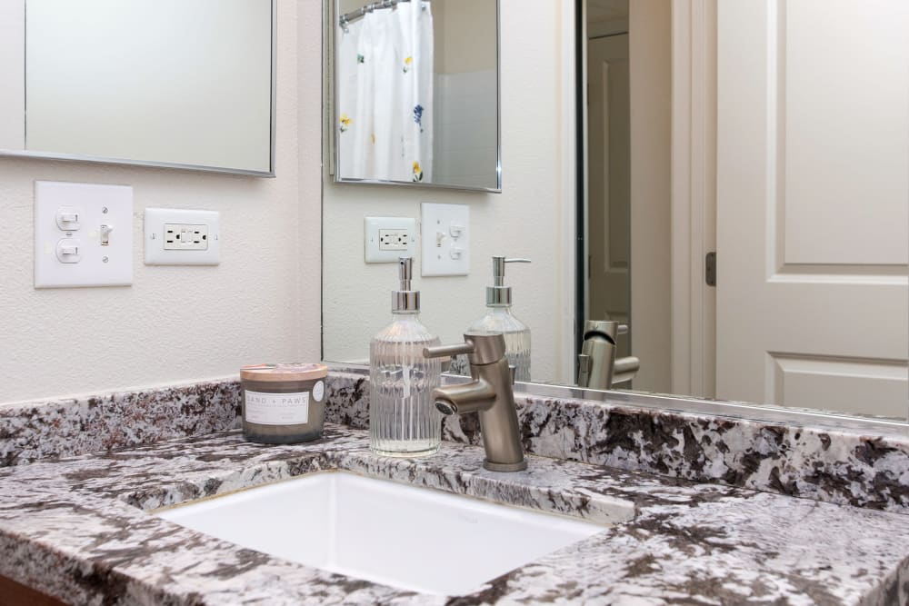 Bathrooms with stone vanity counters at 1010 Pacific in Santa Cruz