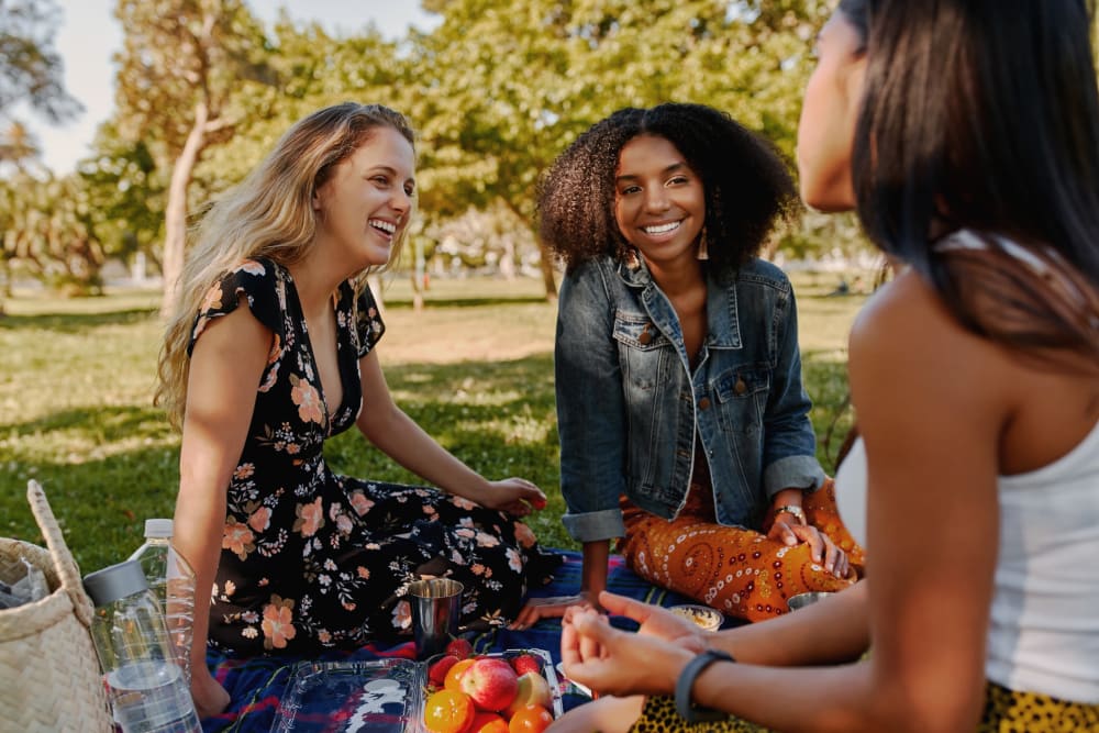 Friends sitting outside in Railside Park near The Planet in Toronto, Ontario